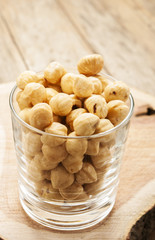 hazelnuts in glass close up on wooden background