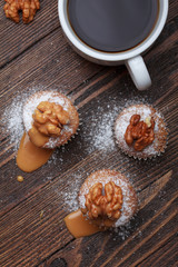Cupcake with nuts and caramel on old wooden table