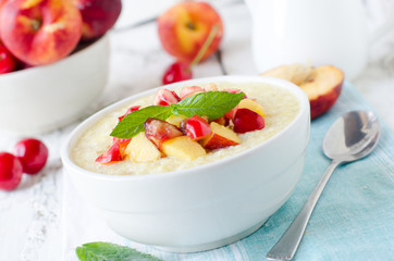 .Milk porridge with peaches and cherries