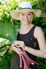 Junge Frau im Garten mit Rhabarber