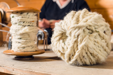 Gesponnene Schafwolle auf Spule und als Ball
