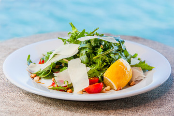 Salad with arugula, cherry tomatoes, pine nuts, parmesan cheese