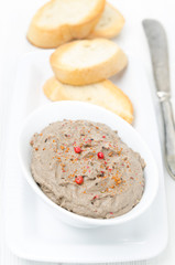 liver pate with pink pepper in a white bowl, top view