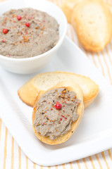 liver pate with pink pepper on toasted bread on a plate
