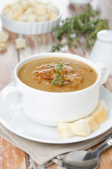 Mushroom cream soup with croutons and thyme in a bowl