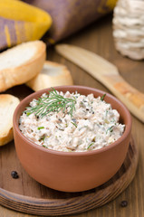 pate of smoked fish with sour cream and greens on a wooden board