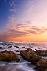Fototapeta na wymiar Sunrise landscape of ocean with waves clouds and rocks