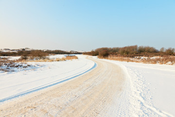 Fototapeta na wymiar Dutch snow winter landscape with path and blue sky. The Netherla