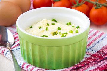 Whipped steam eggs in a cup with green onions for breakfast