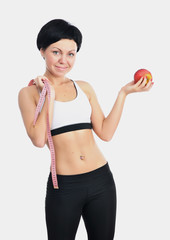 Portrait of young fitness woman with apple