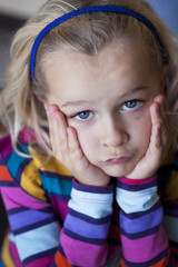 Sulky little girl with head in hands - obrazy, fototapety, plakaty