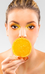 Woman close up with a orange slice