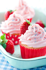 Pink cupcakes with fresh strawberries