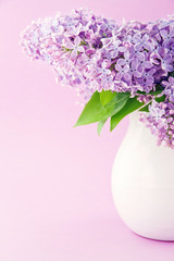 White vase with a bouquet of lilacs