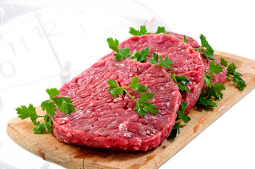 Hamburger of beef on wooden board with parsley