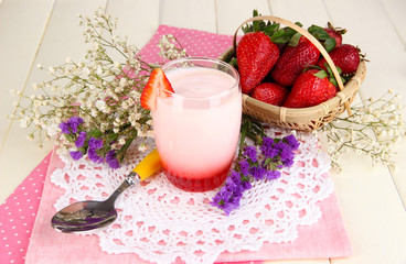 Delicious strawberry yogurt in glass on wooden table close-up