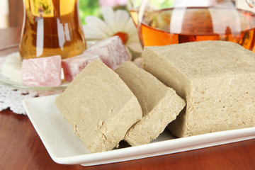 Tasty halva with tea on table in room