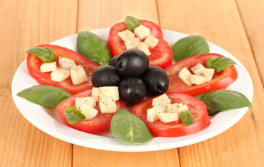 Cheese mozzarella with vegetables in plate on table