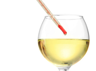 Glass of wine with thermometer, isolated on white
