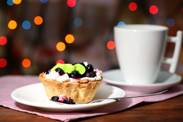 Tasty blackberry cake and cup of beverage,