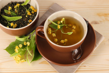 Cup of tea with linden on napkin   wooden table