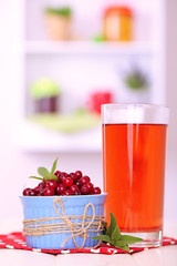 Glass of cranberry juice and ripe red cranberries in bowl