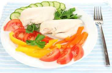 Boiled chicken breast on plate with vegetables close up