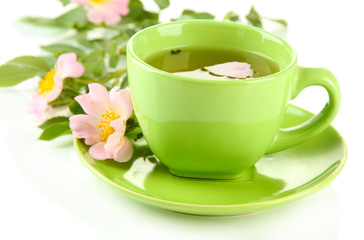 Cup of herbal tea with hip rose flowers, isolated on white