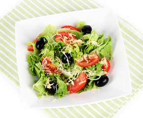 Light salad on plate on napkin  isolated on white