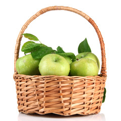 Juicy green apples with leaves in basket, isolated on white