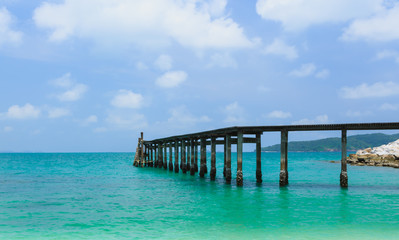 Fototapeta na wymiar Wooden footbridge over the water near the beach