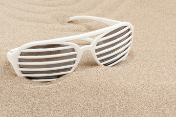 Fototapeta na wymiar funny sun glasses in sand