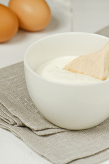 Sour cream with eggs in the background