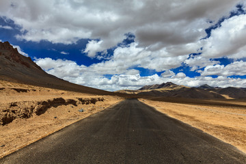 Road on plains in Himalayas with mountains