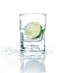 Vodka with lime in glass beaker, isolated on white