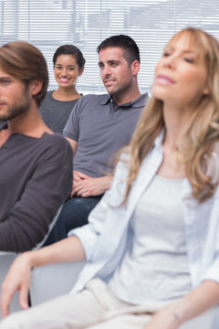 Patients listening in group therapy with one girl smiling