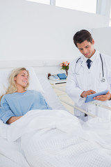 Fototapeta premium Smiling doctor showing digital tablet