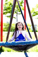 Bambina felice sull'altalena al parco giochi
