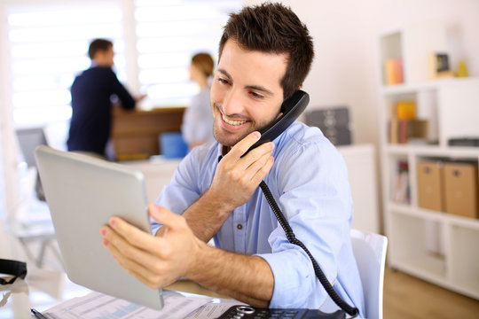 Cheerful Man In Office Answering The Phone