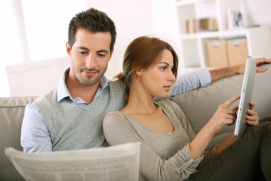 Couple reading news on both press and internet