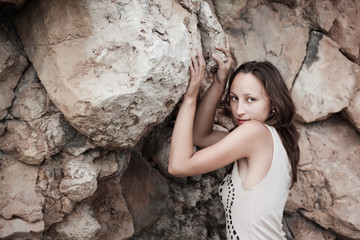 beautiful girl posing on a stone wall background