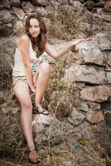 beautiful girl posing on a stone wall background