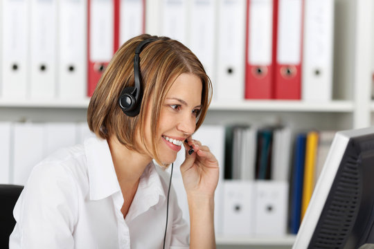 Serious smiling businesswoman talking on headset