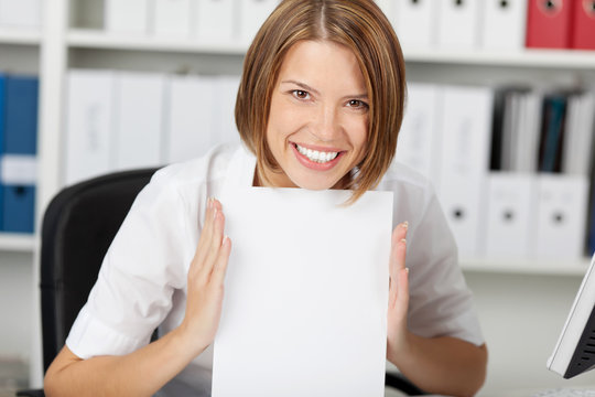 Smiling businesswoman shows white paper