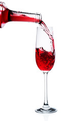 Red wine poured in a glass isolated on white
