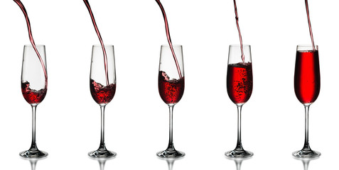Red wine being poured in a wine glass isolated on white