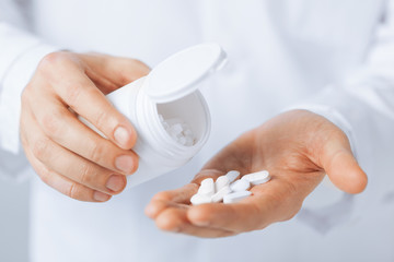 doctor hands holding white pack and pills
