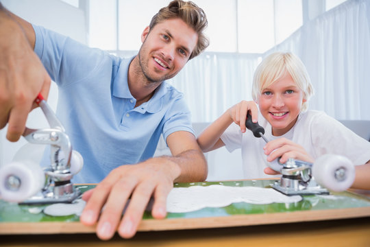 Father and son repairing a skateboard - Powered by Adobe