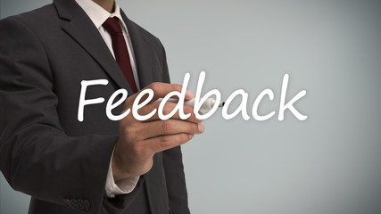Businessman writing the word feedback