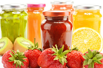 Composition with jars of fruity jams on white. Preserved fruits